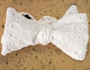 Nœud en broderie Anglaise blanc sur marbre