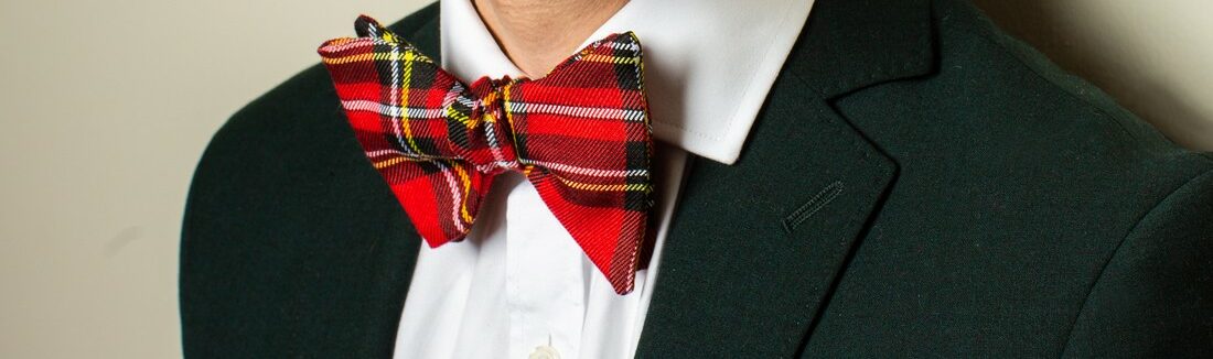 Nœud papillon en tartan tartan rouge porté sur veste verte